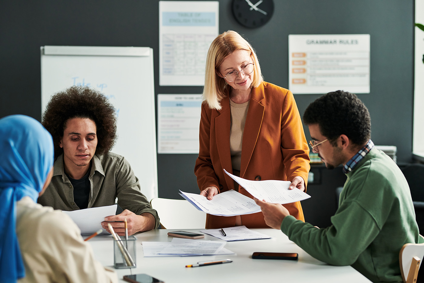 Classroom with students and a teacher passing papers