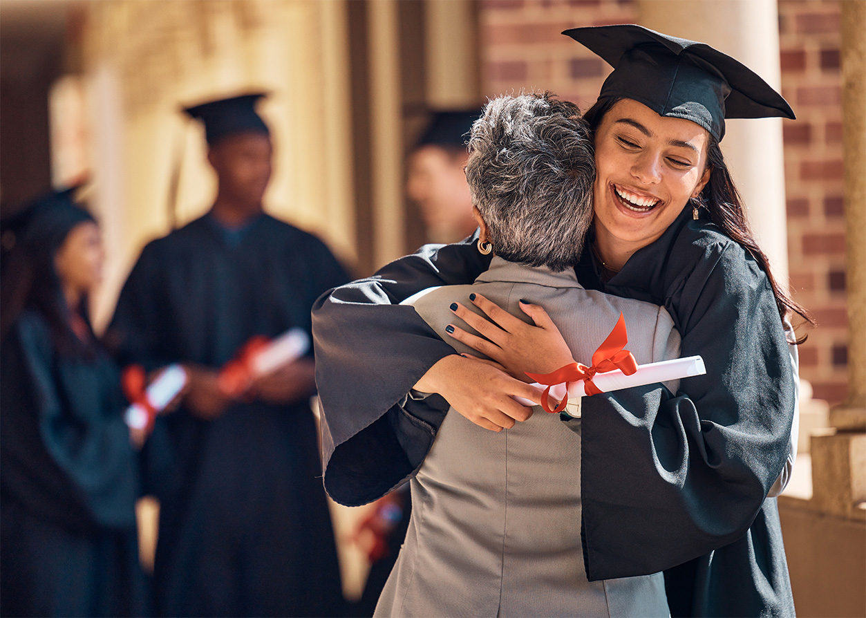 Graduate hugging family member after ceremony